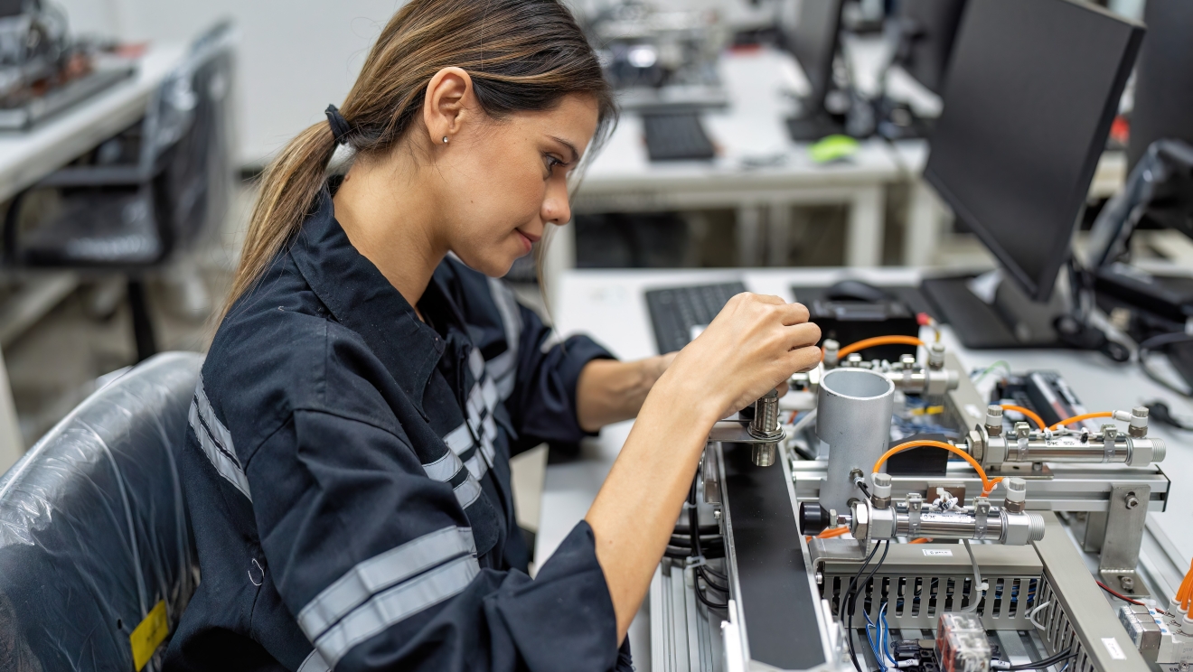 Young woman working at robot factory