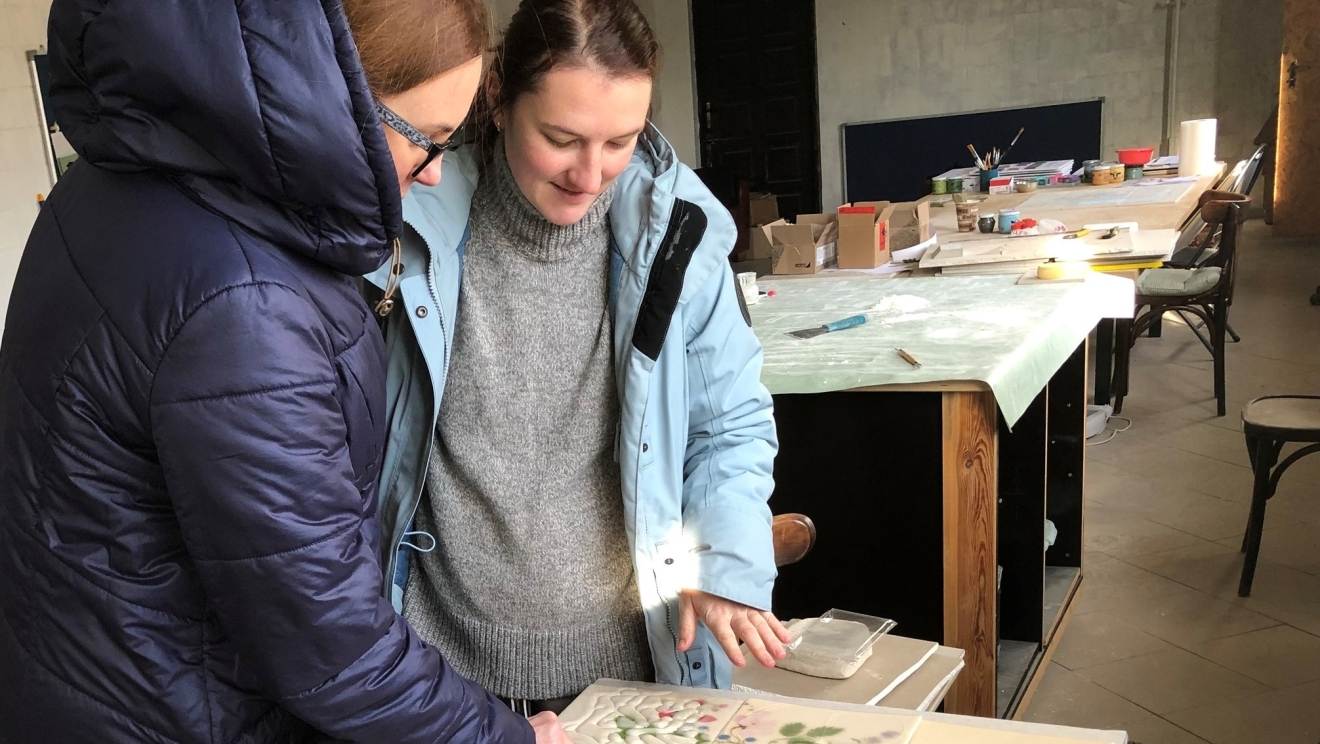 Ukrainian women examine a tile in a factory